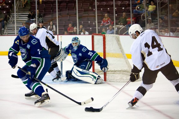 Hershey Bears Center Matt Watkins assists Josh Brittain in scoring on September 27, 2013. (Ann Erling Gofus/The Hockey Writers)