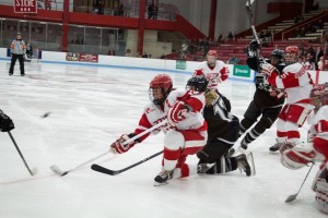 Boston, March 1, 2014 -- Boston University women's hockey defense Kaleigh Fratkin, center, and Providence College women's hockey forward Janine Weber, center right, play during the East Quarterfinals. The game was held at Boston University's Walter Brown Arena in Boston, MA. BU won 3-2. Photograph by Carolyn Bick. © Carolyn Bick/BUNS 2014.