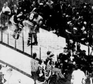 Arnie Brown and Mike McMahon follow Vic Hadfield over the glass.